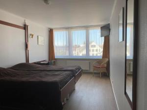 a hotel room with a bed and a window at Vakantiecentrum Zeelinde in De Haan