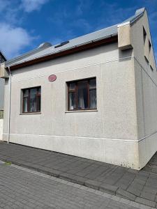 ein Gebäude mit zwei Seitenfenstern in der Unterkunft Lítið einbýlishús á besta stað. in Vestmannaeyjar