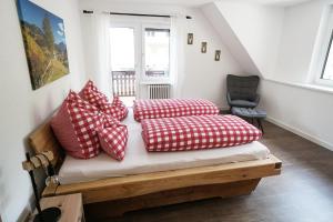 a bed with red and white pillows in a room at Hörnleberg - Stubenhof, Black Forest in Simonswald