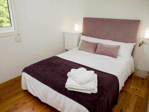 a bedroom with a large bed with two towels on it at A Casiña Casa Rural en Galicia in Ourense