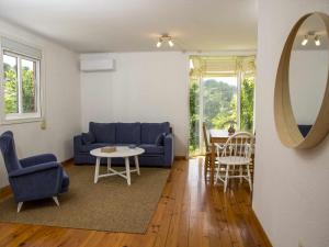ein Wohnzimmer mit einem blauen Sofa und einem Tisch in der Unterkunft A Casiña Casa Rural en Galicia in Ourense