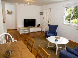 奧倫塞的住宿－A Casiña Casa Rural en Galicia，客厅配有电视和桌椅