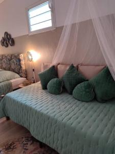 a bedroom with a bed with green pillows at Entre Terre & Mer (Sainte rose)974 in Sainte-Rose