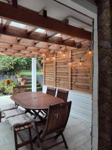 a wooden table and chairs on a patio at Entre Terre & Mer (Sainte rose)974 in Sainte-Rose