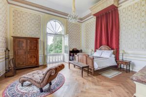 sypialnia z łóżkiem i dużym oknem w obiekcie Chateau de Pourpry w mieście Damiatte
