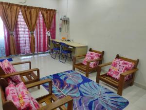 a room with three chairs and a table and a desk at Homestay Intan Payung Bukit Katil Tuah Perdana in Malacca +6 photos