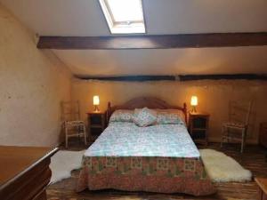 een slaapkamer met een bed met 2 tafels en 2 stoelen bij Cosy private cottage in Condac
