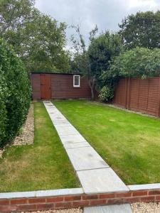 a garden with a fence and a grass yard at Modern Ground Floor Garden Apartment With Parking in South Hayling
