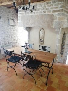 een tafel en stoelen in een kamer met een stenen muur bij Cosy private cottage in Condac