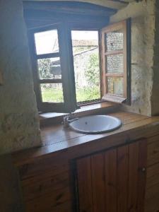 een badkamer met een wastafel en een raam bij Cosy private cottage in Condac