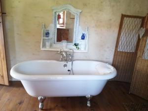 een badkamer met een wit bad en een spiegel bij Cosy private cottage in Condac
