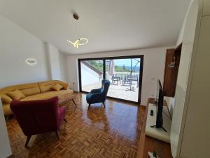 a living room with a couch and a tv at Luxury Penthouse with panoramic view in Ulcinj