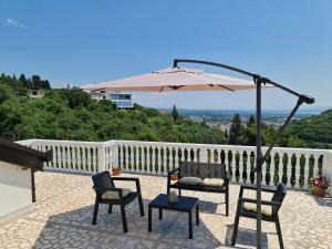 a patio with two chairs and an umbrella at Luxury Penthouse with panoramic view in Ulcinj