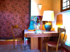 CastelcuccoにあるLa Casa di Lauraのダイニングルーム(ランプと椅子2脚付)
