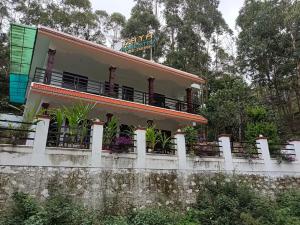 a house on top of a stone wall at Voyage Munnar Laya Home Stay in Suryanelli