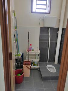 a small bathroom with a toilet and a window at Homestay Intan Payung Bukit Katil Tuah Perdana in Malacca