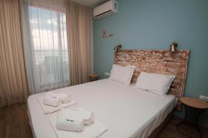 ソゾポルにあるRomantic Getaway 1-BD Apartment with Sea View by Flat Mаnаgerのタオルが敷かれたベッドのある寝室