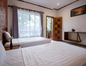 1 dormitorio con 2 camas y ventana en Lucky Private Boutique Pool Villa, en Siem Reap