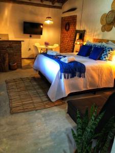 a bedroom with a large bed with blue pillows at Casinhas em Terras Frias in Santa Maria Madalena