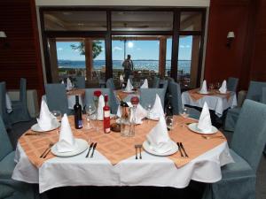 a dining room with a table with white napkins and wine glasses at Hotel Laguna in Privlaka