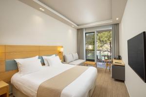 帕莱欧卡斯提撒Akrotiri Beach Resort Hotel - Adult Friendly的配有床和电视的酒店房间