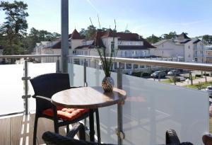 a table and chairs on a balcony with a view of a city at Ferienwohnung Baabe Kapitan Blaubar Ref. (Ref.189689-1) in Baabe