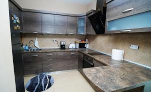 a kitchen with wooden cabinets and a counter top at Penev guest house in Glavatartsi