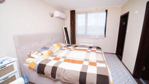 um quarto com uma cama com um cobertor xadrez em Penev guest house em Glavatartsi