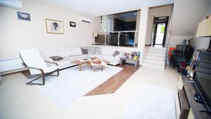 a living room with a white couch and a table at Penev guest house in Glavatartsi