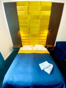a bedroom with a blue bed with a yellow headboard at Old Town Gertrudy Apartment - Topolove Rooms & Apartments in Krakow