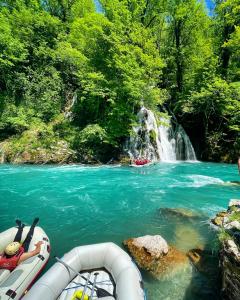 un grupo de personas en barcos en un río con una cascada en Rafting Camp Modra Rijeka, en Šćepan-Polje