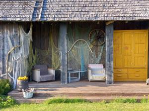 een veranda van een huis met een tafel en stoelen bij Pérka kodumajutus in Häädemeeste