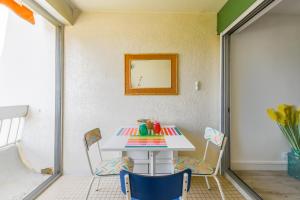 Zimmer mit einem Tisch und Stühlen auf einer Terrasse in der Unterkunft Le Superbe Bahia / proche mer / clim / Terrasse / parking privé in La Grande-Motte