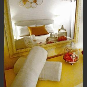 ein Schlafzimmer mit einem Bett mit einem Spiegel und einem Sofa in der Unterkunft Welcome Friends&Family in Ceglie Messapica
