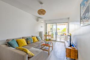 ein Wohnzimmer mit einem Sofa und einem Tisch in der Unterkunft Le Superbe Bahia / proche mer / clim / Terrasse / parking privé in La Grande-Motte