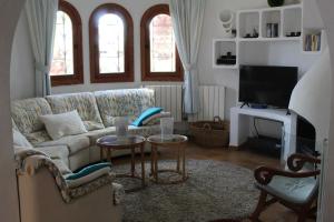 a living room with a couch and a tv at Casa Caliente in Cala Santanyi