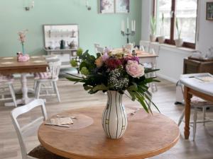 a vase filled with flowers sitting on a table at Bed&Breakfast Eifelpension Brückenschenke in Fuchshofen