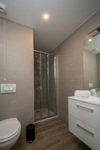 uma casa de banho com um chuveiro, um WC e um lavatório. em Lagrange Apart Hôtel Mulhouse Saint Sauveur em Mulhouse