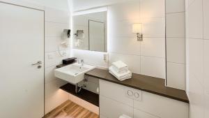 a white bathroom with a sink and a mirror at Europa Hotel Kühlungsborn in Kühlungsborn
