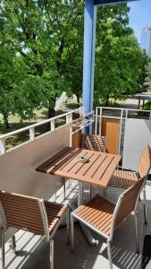 a wooden table and chairs on a balcony with trees at Berlin mednow 1 in Berlin