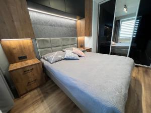 sypialnia z dużym łóżkiem i lustrem w obiekcie Tricity Apartments - Wilga Park w Gdańsku