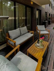 eine Terrasse mit einem Sofa und einem Tisch auf einer Terrasse in der Unterkunft GREEN CORNER Apartment in Bukarest
