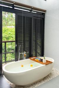 La salle de bains est pourvue d'une baignoire et d'une fenêtre. dans l'établissement Zenubud, à Ubud