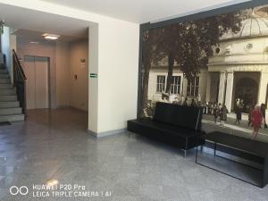 une chambre avec une photo d'un bâtiment et un canapé dans l'établissement Apartament Zuza, à Polanica-Zdrój