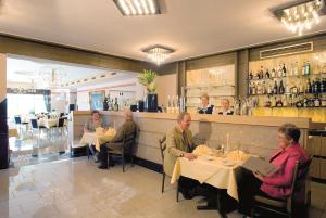 een groep mensen die aan tafels in een restaurant zitten bij Hotel Schünemann in Steinfurt