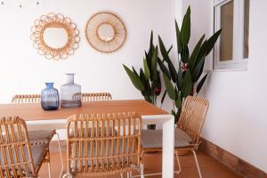 uma sala de jantar com uma mesa com cadeiras e espelhos em Apartamento La Barca em El Rompido