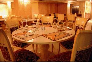 a dining room with a white table and chairs at Oasis Hotel in Skála