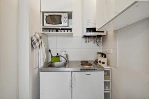 a small kitchen with a sink and a microwave at Arbio I Urban Apartment in Berlin +13 photos