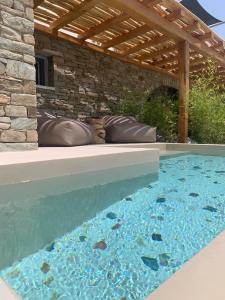 a swimming pool in a backyard with a wooden pergola at Gianemma Luxury Apartments in Mylopotas