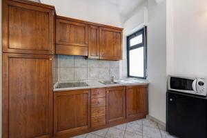 a kitchen with wooden cabinets and a sink and a window at 18 Mehari in Varigotti +18 photos